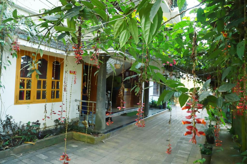 a building with red flowers hanging from a tree at Clement homes in Kalpetta