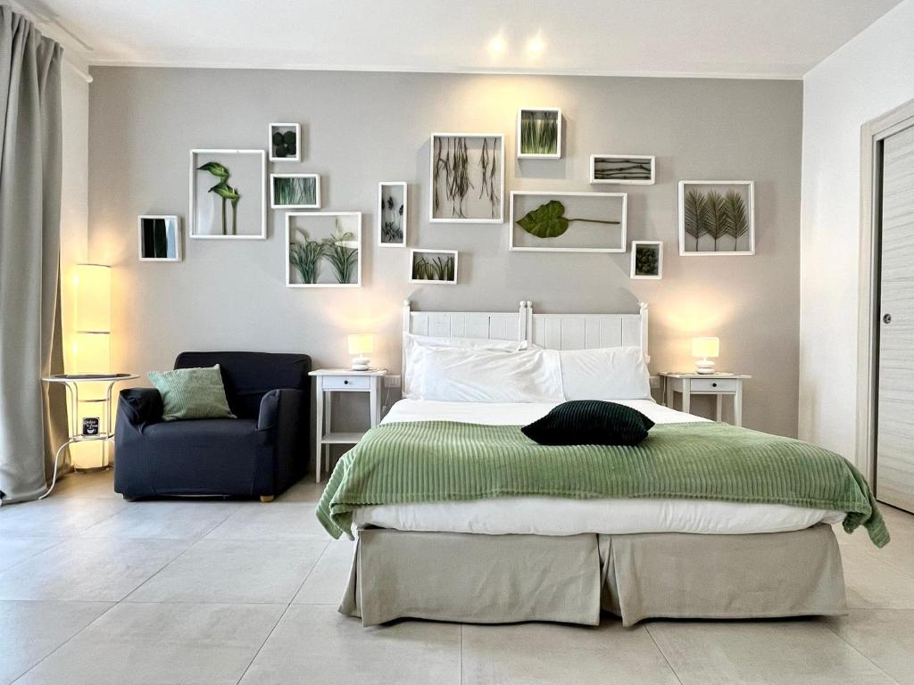 a bedroom with a large bed and a blue chair at Giardino Botanico in Ragusa