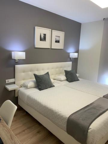 a bedroom with a large bed with two pillows at Hostal el Rocio in Paracuellos de Jarama