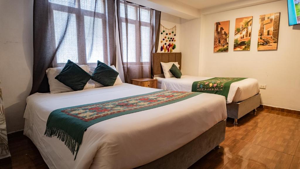 a hotel room with two beds and a window at Munay Ñusta Cusco in Cusco