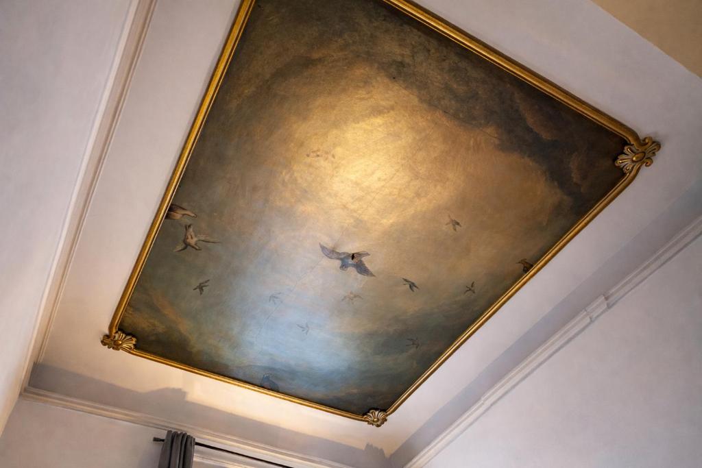 a painting on the ceiling of a room with birds at Suite historique classée Avignon intra-muros in Avignon