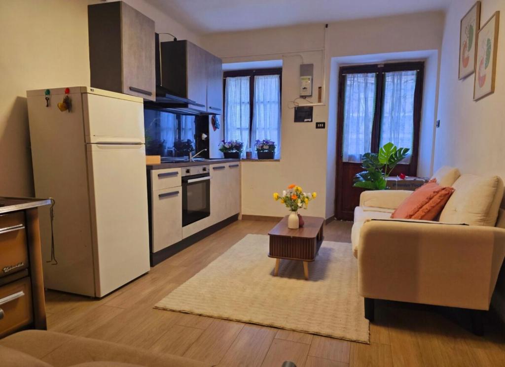 a kitchen and a living room with a white refrigerator at Alpine View Varzo - Train Station in Varzo