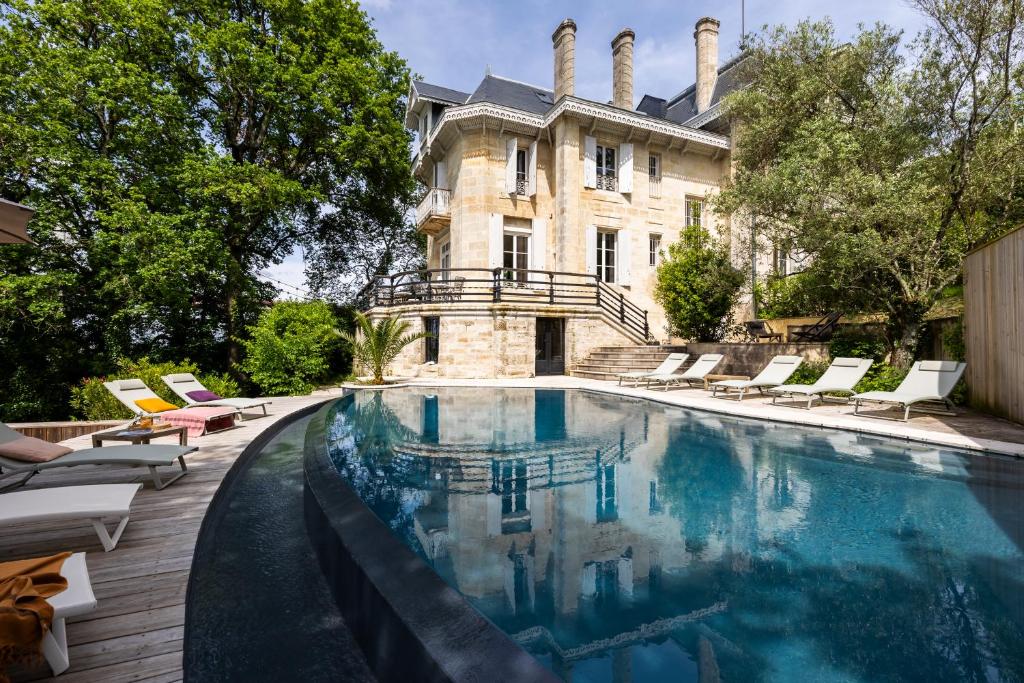 a swimming pool in front of a house at chalet baron in Lormont