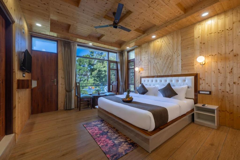 a bedroom with a large bed in a room with wooden walls at Evening Sky Hotel - Kasauli !!! in Kasauli