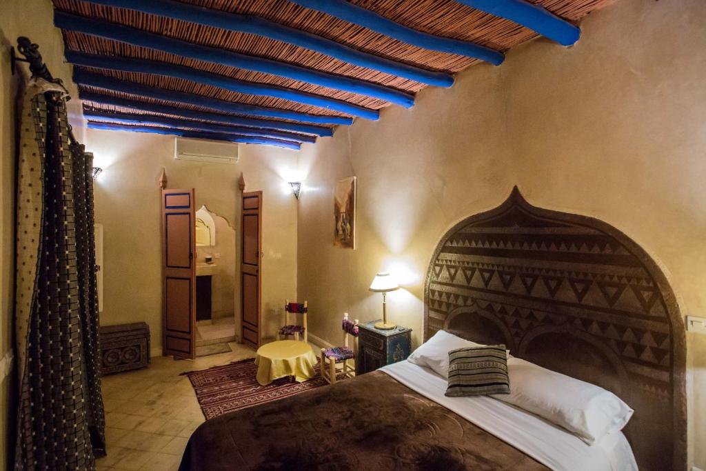 een slaapkamer met een groot bed en een blauw plafond bij Riad Light Of Sun in Marrakesh