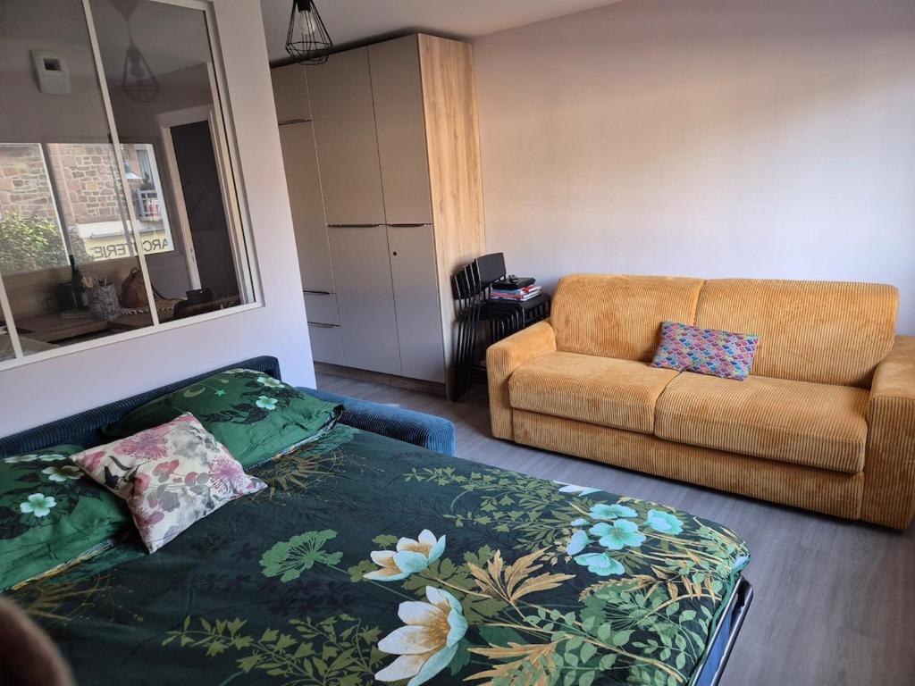 a living room with a bed and a couch at Ty Joty in Perros-Guirec