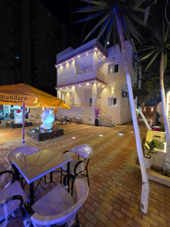 a patio with a table and chairs and a building at Elmandara Residence in Alexandria