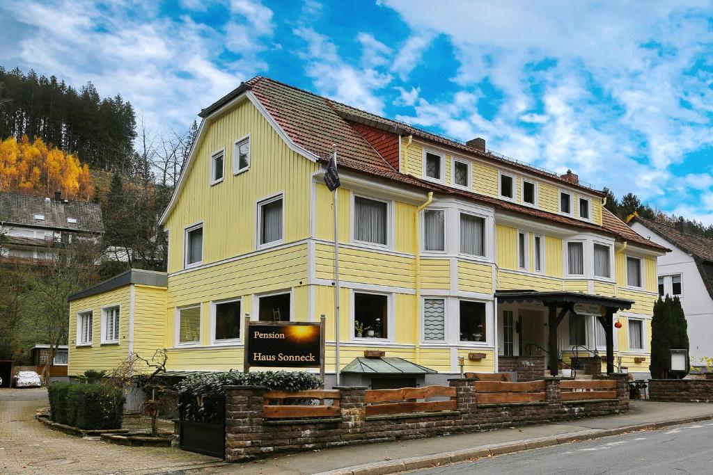 a yellow house with a sign in front of it at Pension Haus Sonneck in Wildemann
