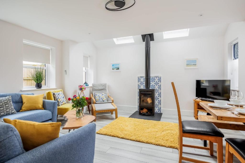 a living room with a couch and a fireplace at Charlotte Cottage - Minutes from Poole Park, with Feature Log Burner in Poole