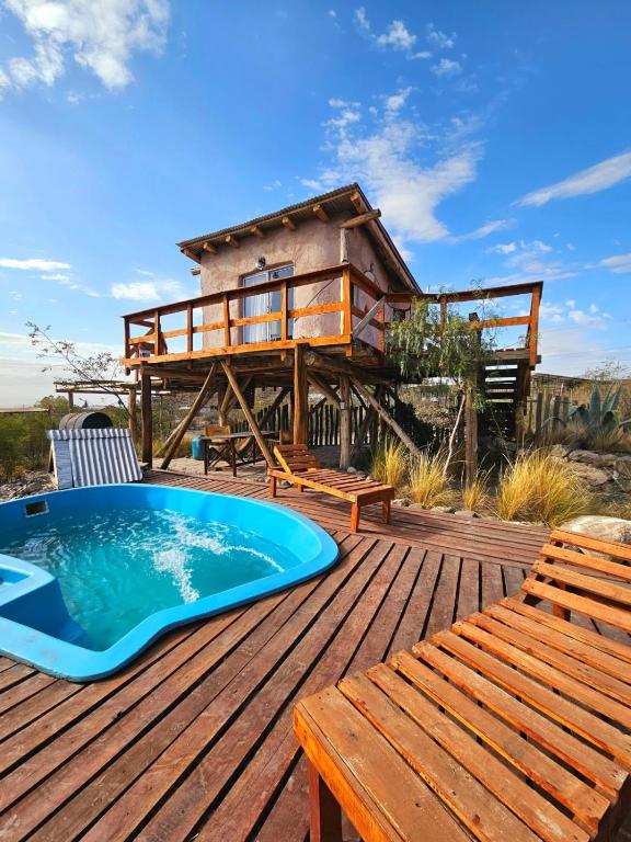 a deck with a hot tub and a house at ECOCABAÑAS CERRO ARKO in Mendoza