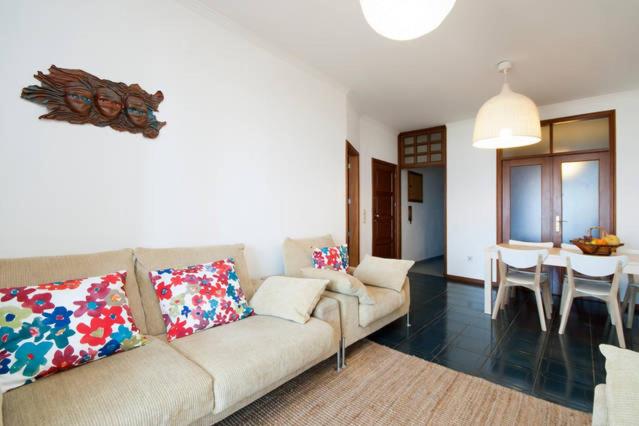 een woonkamer met een bank en een eetkamer bij Em frente à Praia e Marina in Vila do Conde