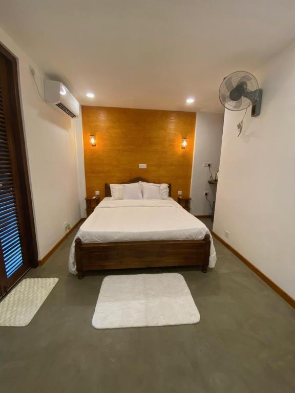 a bedroom with a bed in a room with rugs at Elite Nest in Ahangama