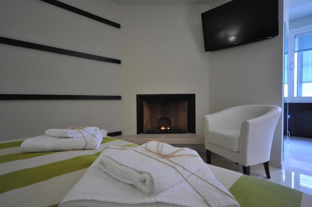 a bedroom with a bed and a chair and a fireplace at Gatto Bianco House in Bari