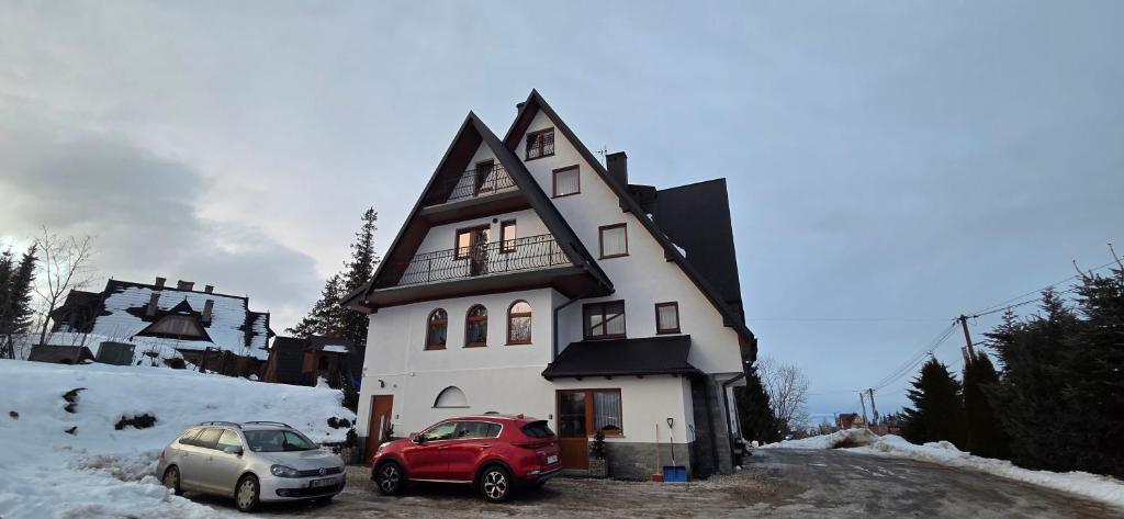 a house with two cars parked in front of it at Willa na Bartkowym Wierchu in Gliczarów Górny