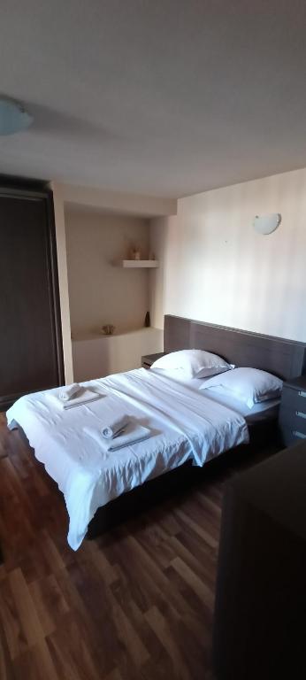 a bedroom with a large bed with white sheets and pillows at Cazare Garden Bragadiru Clinceni Domnești in Ordoreanu