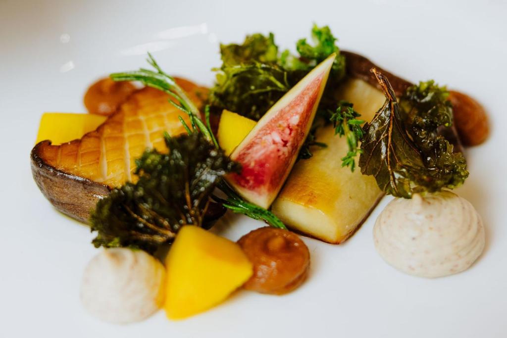 Artful arrangement of roasted mushrooms, fig wedge and vegetables atop creamy mashed potato.