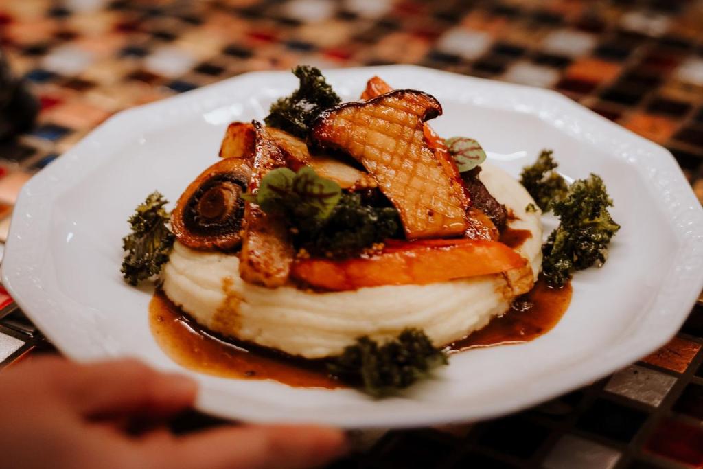 Mashed potato topped with roasted root vegetables, grilled mushrooms and crispy kale garnishes.