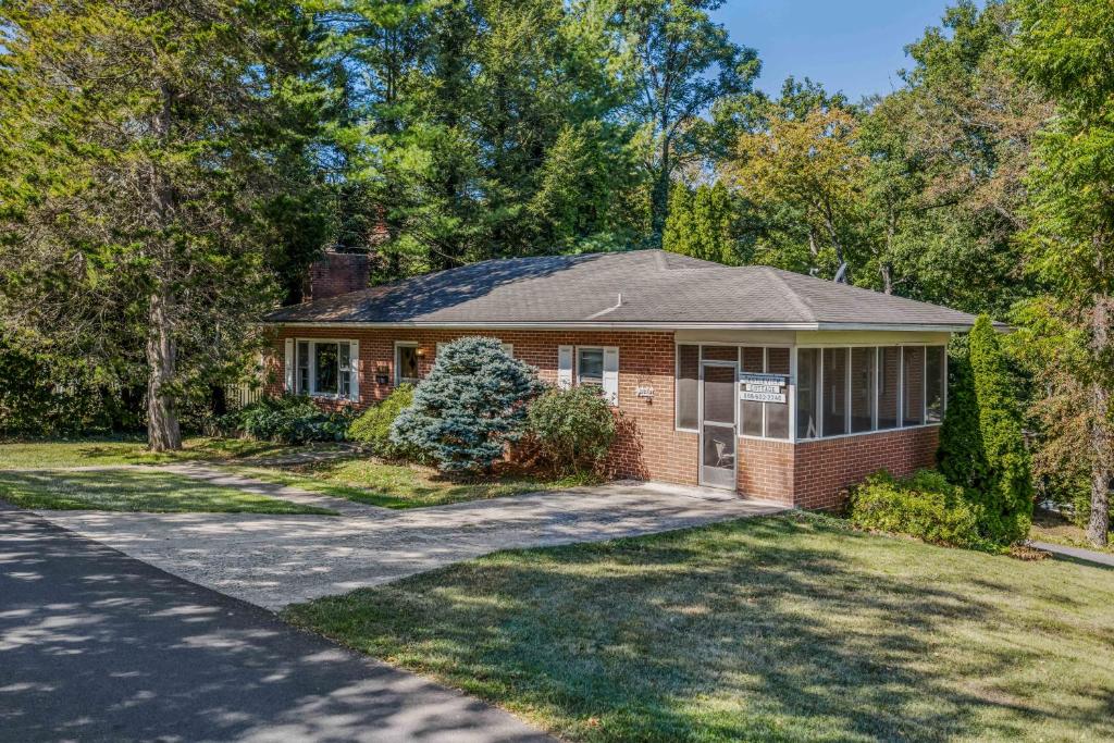 a red brick house with a driveway at Castle View - Wifi, Pet Friendly, Screen Porch, Game Room, Grill, Family Friendly, Kid Friendly, Fireplace in Berkeley Springs