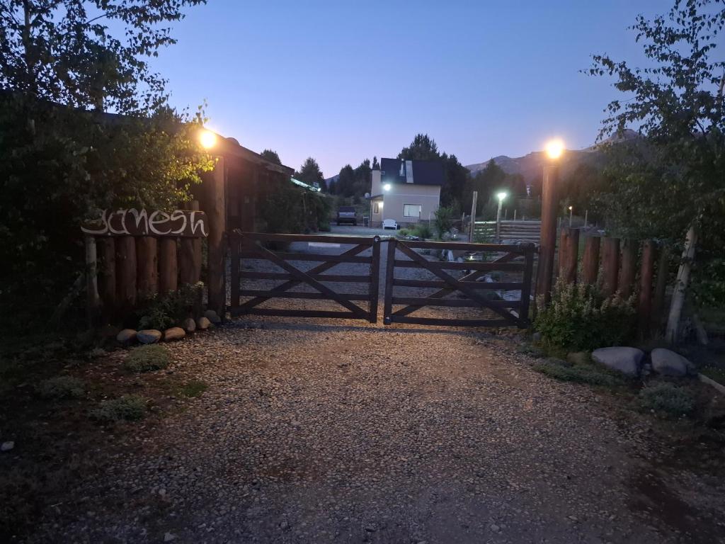 a wooden gate in a driveway at night at Complejo Cabañas Ganesh in Lago Meliquina