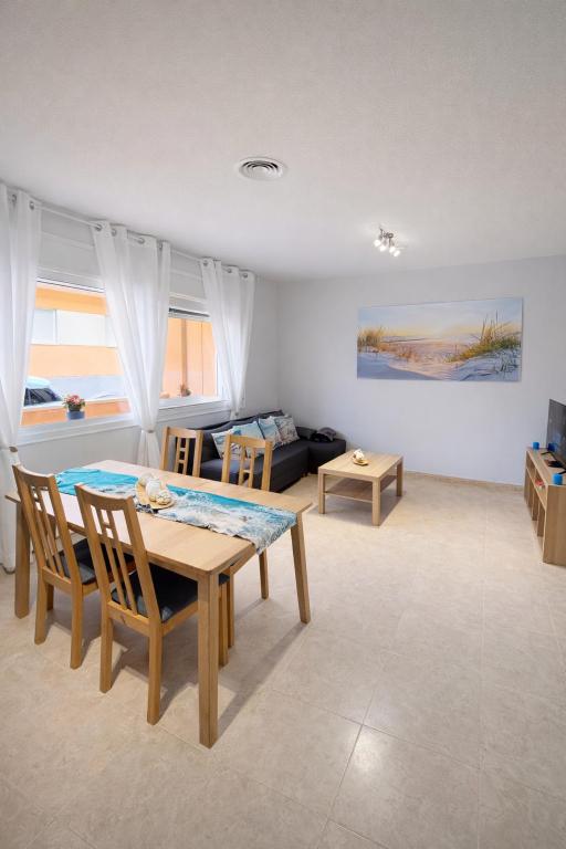 a living room with a table and chairs and a couch at Apartamento Turístico Les Dunes in Els Muntells