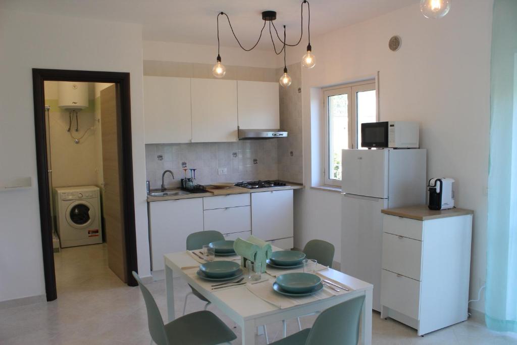 a kitchen with a table and chairs and a kitchen with a refrigerator at Apartment - Pizzo Beach Club in Fondaco Vecchio