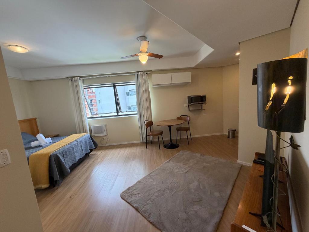 a bedroom with a bed and a table in a room at Hotel Flat Biena Parque Ibirapuera 810 incluso estacionamento in São Paulo