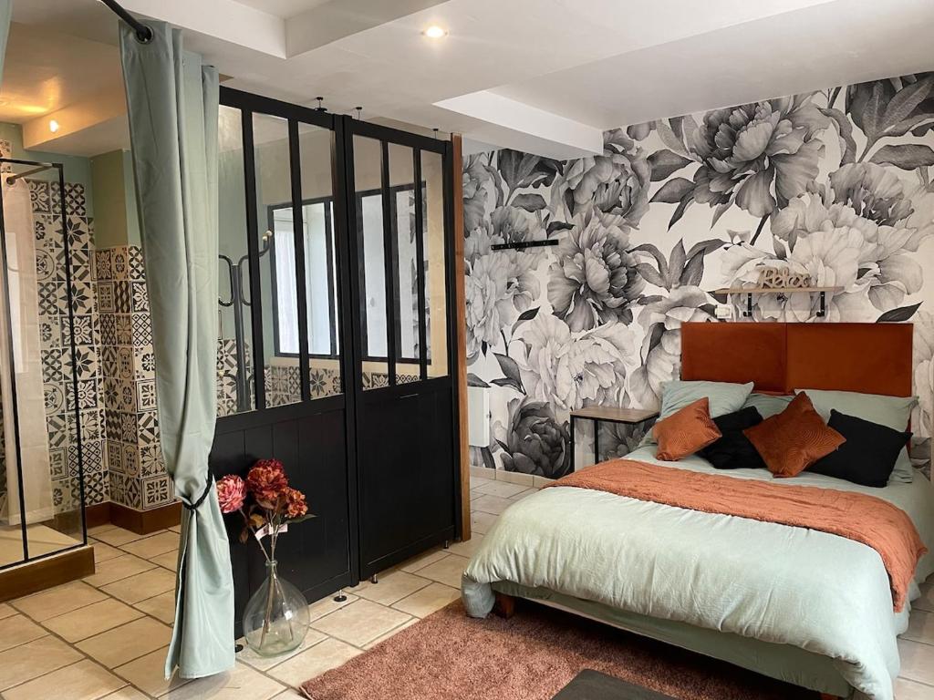 a bedroom with a bed and a floral wall at Le Cosy 8km du futuroscope in Beaumont