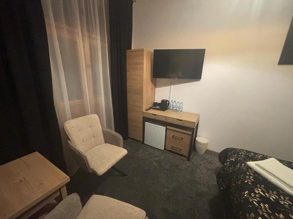 a hotel room with a bed and a chair and a television at Pokoje Gościnne U Niny - Szklarska Poręba in Szklarska Poręba