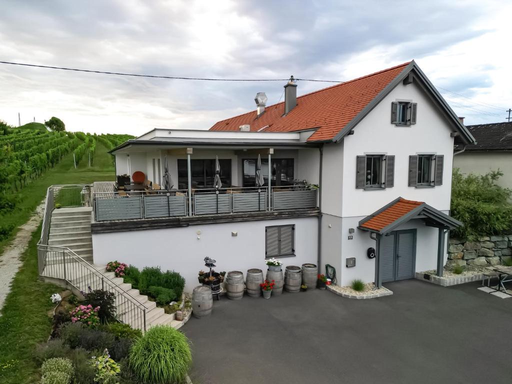a white house with a balcony and a yard at Walters Weinquartier in Eisenberg an der Pinka