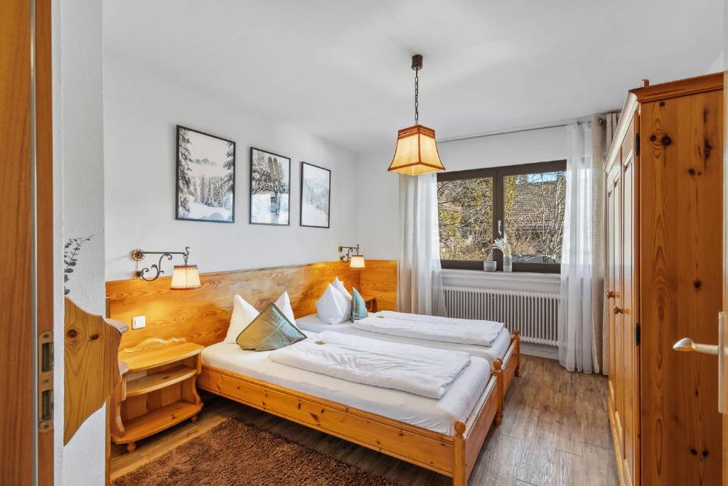 a bedroom with a bed and a window at Gaestehaus Florian - Ferienwohnungen in Grainau