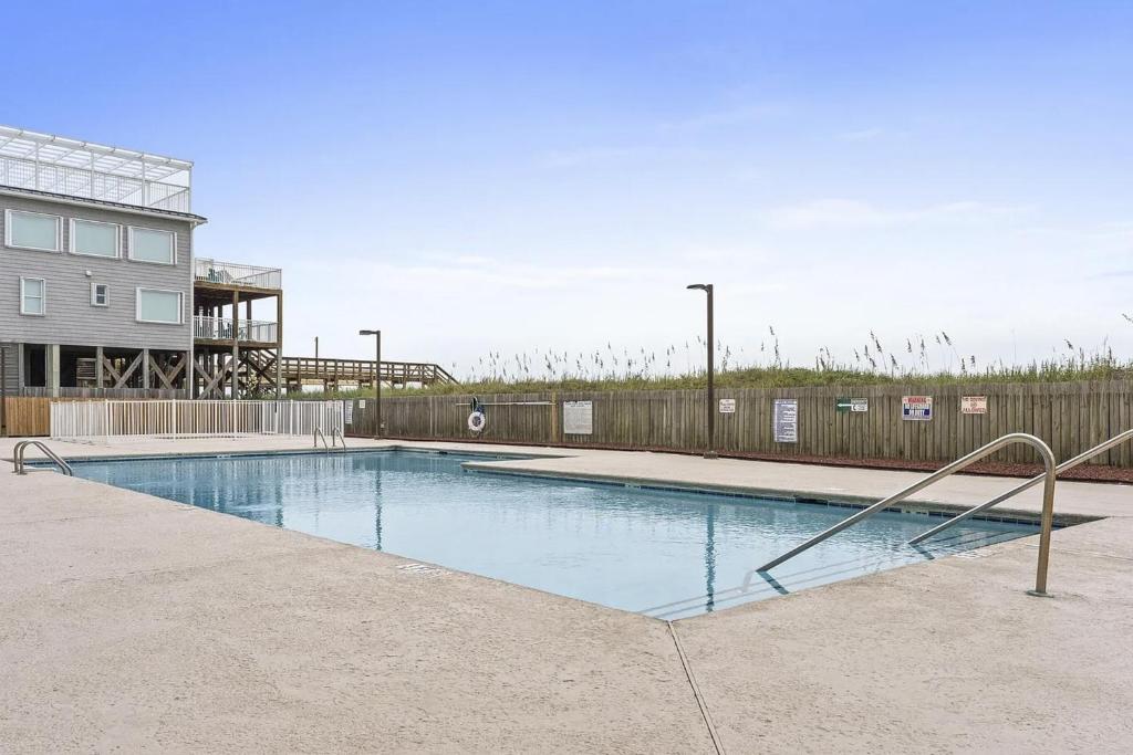 an empty swimming pool in front of a building at OIB74 Kat Cove 2 in Ocean Isle Beach