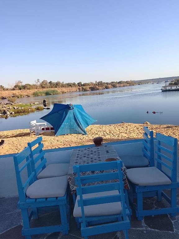 a table and chairs on a beach with a body of water at Mostafa Gest House in Asyut