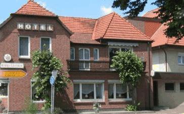 ein großes Backsteinhaus mit orangefarbenem Dach in der Unterkunft Röhrs Gasthof in Sottrum