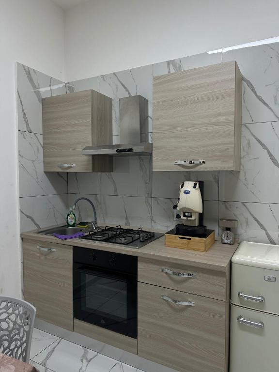 a kitchen with wooden cabinets and a stove top oven at Binario104 in Naples
