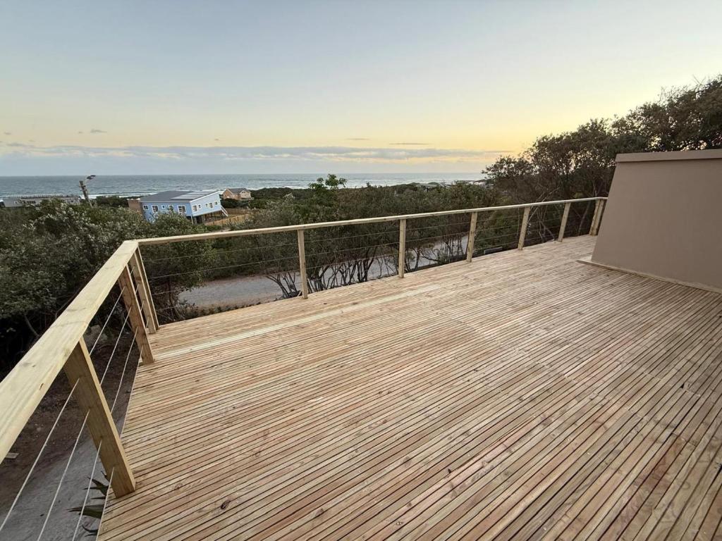 a wooden deck with a view of the ocean at Seenekal views in Cannon Rocks