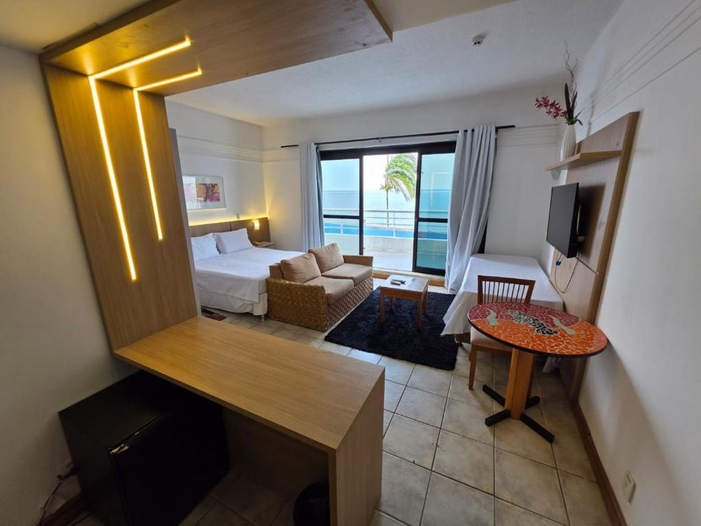 a bedroom with a bed and a living room at Tropical Executive Flat Vista Maravilhosa do Rio in Manaus