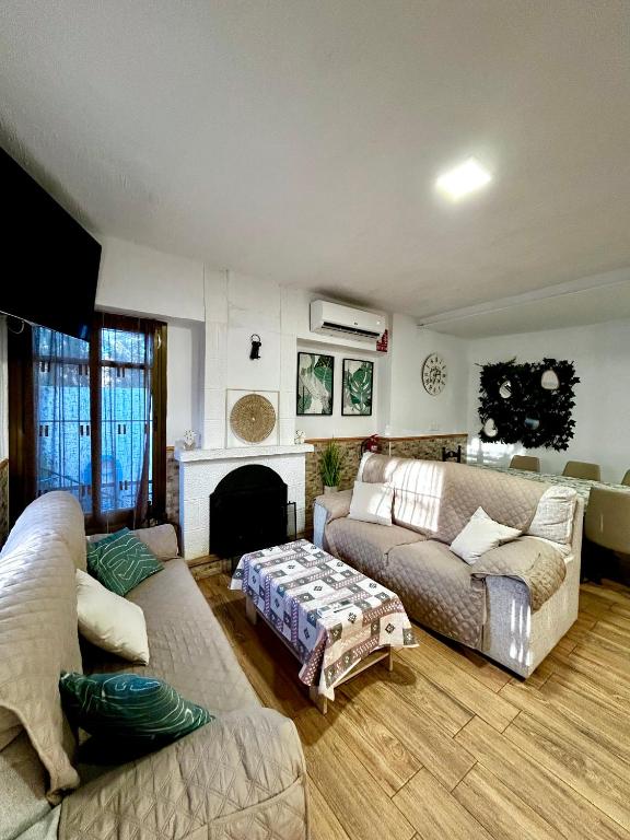 a living room with two couches and a fireplace at Casa Rural Abuelo Raimundo in Ossa de Montiel