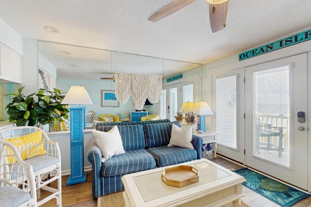 a living room with a blue couch and a table at OIB88 PierSide Paradise in Ocean Isle Beach