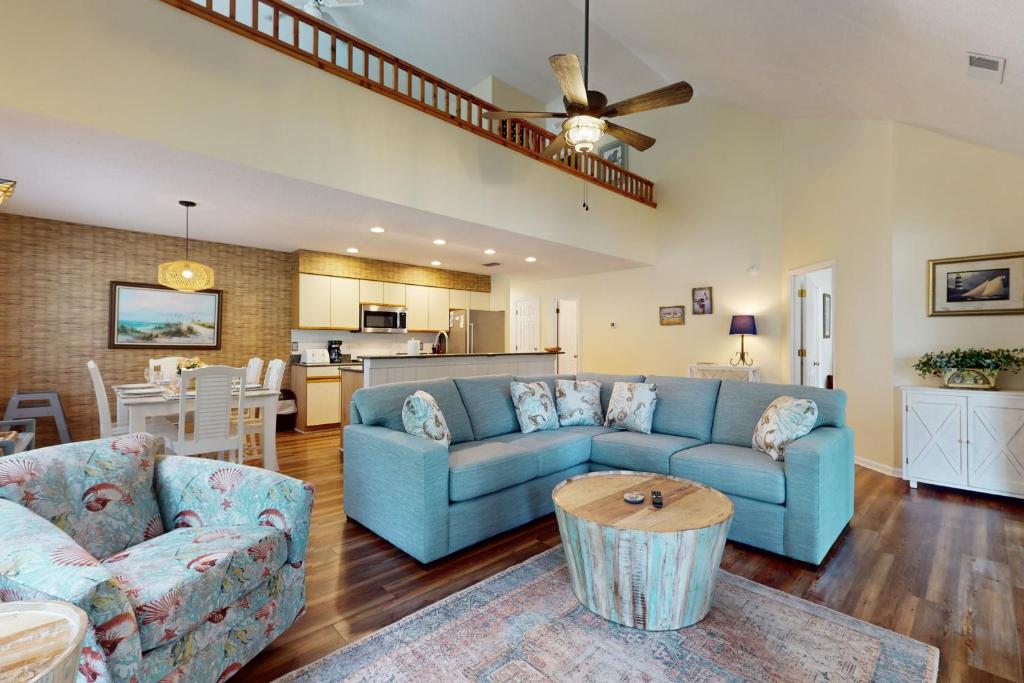 a living room with a blue couch and a table at SB25A Clubhouse Villa 2BR in Sunset Beach