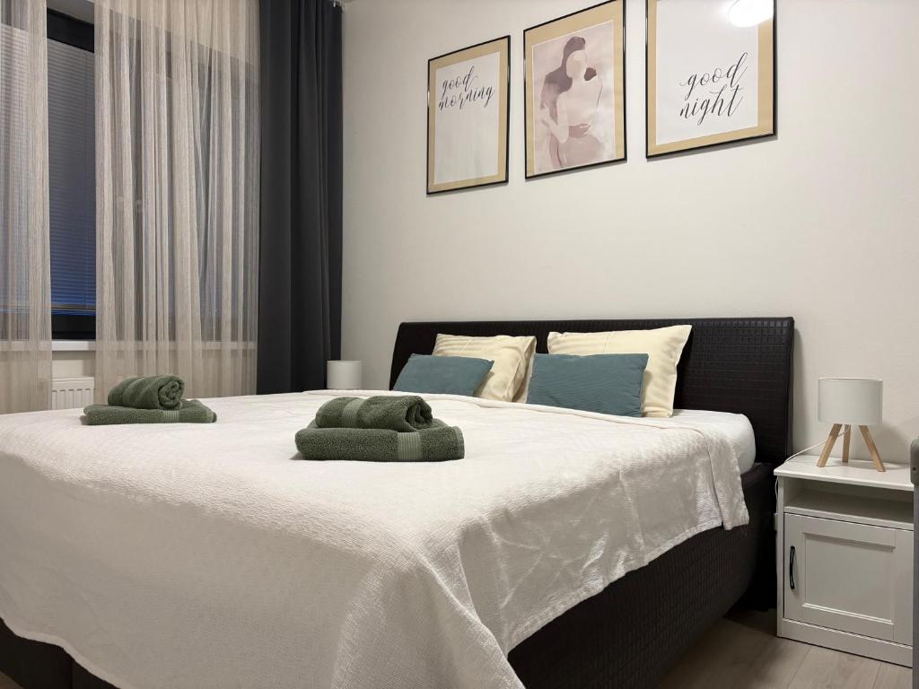 a bedroom with a large bed with two green towels on it at Apartman SPORKA in Púchov