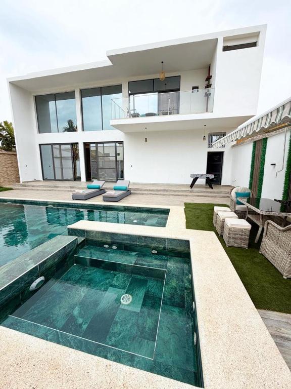 a house with a swimming pool in front of a house at La villa Bella Vista in Somone