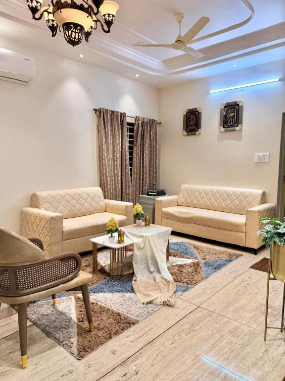 a living room with two couches and a table at Dar E Noor in Hyderabad