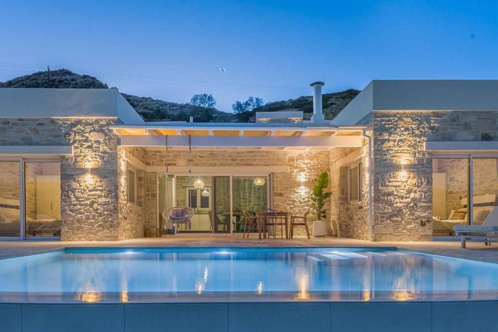 a villa with a swimming pool in front of a house at Villa Vidan in Matala by South Cretan Villas in Matala