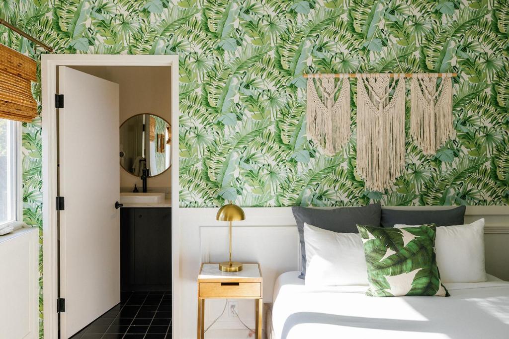 a bedroom with a bed with a green and white wallpaper at Noon on Sunset Hill in Los Angeles