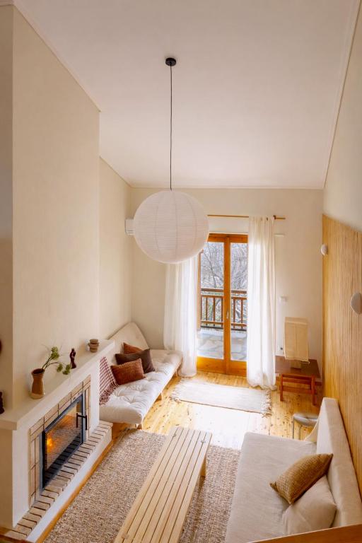 a living room with a couch and a fireplace at VYTINA LOFTS - Cozy 2-Level Loft Apartments with Fireplace & Mountain Views in Vitina