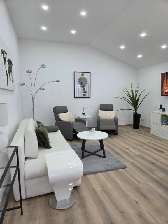 a living room with a white couch and a table at Kings Apartments in Ingolstadt