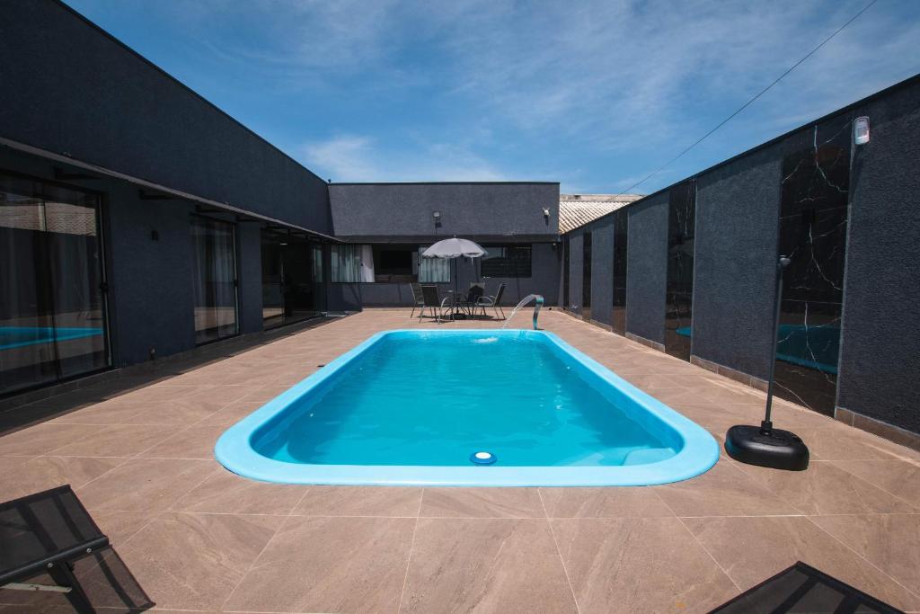 a swimming pool on a patio with a building at Casa grande alto padrão á 100 metros do mar in Guaratuba
