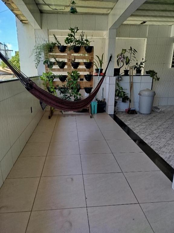 a hammock in a room with potted plants at Lar da Lilika Temporada in Cabo Frio