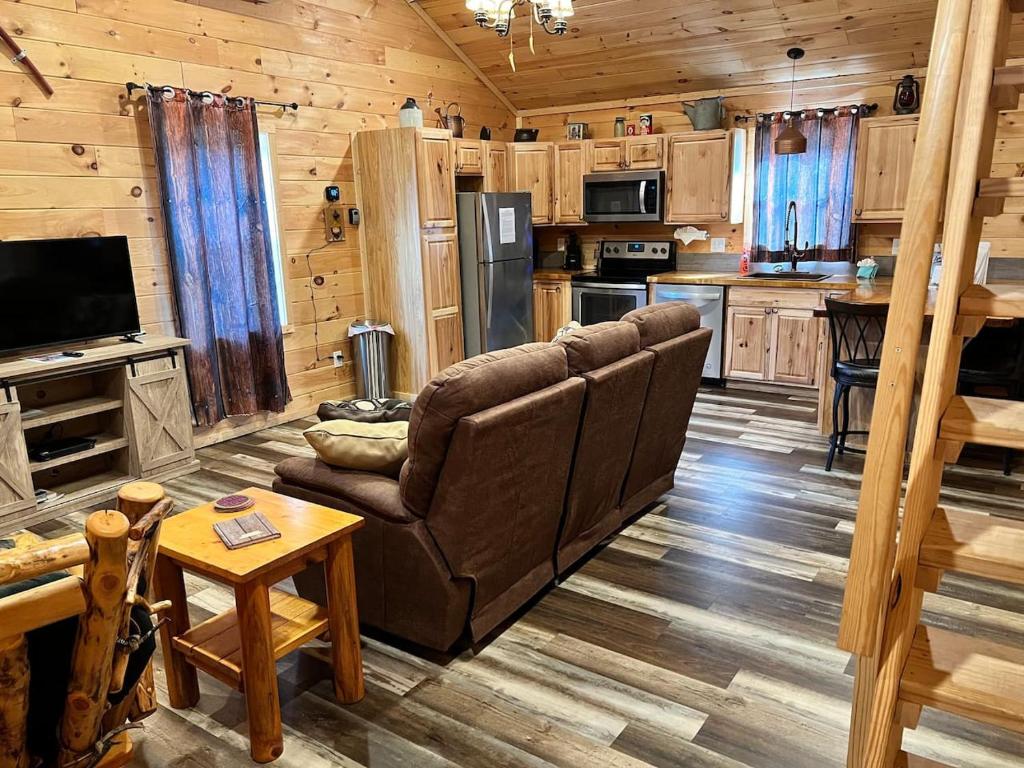a living room with a couch and a kitchen at Country Bumpkin Cabin in Banner Elk