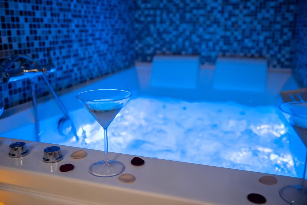 a martini glass sitting on the edge of a bath tub at L' Antre de L' Ange in Trédarzec